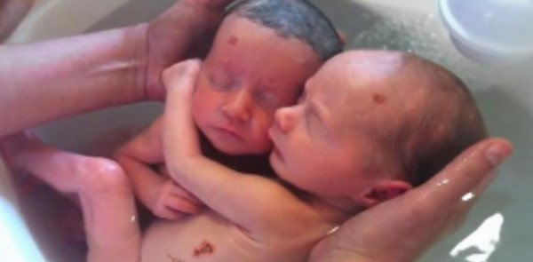 Newborn twins appear to hug each other during bath time VIDEO
